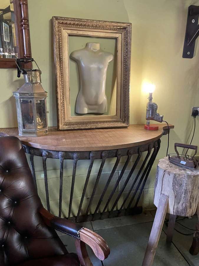 A cast iron Agricultural hay rack with a solid elm top console table