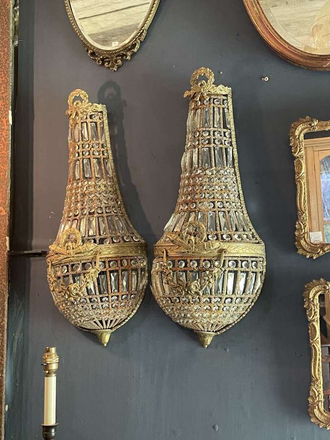 A pair of large brass and glass hanging wall light sconces.