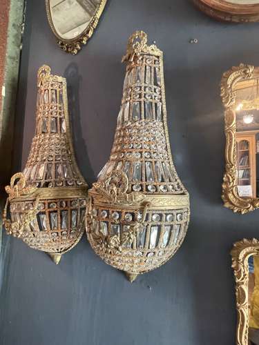A pair of large brass and glass hanging wall light sconces.