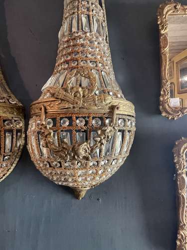 A pair of large brass and glass hanging wall light sconces.