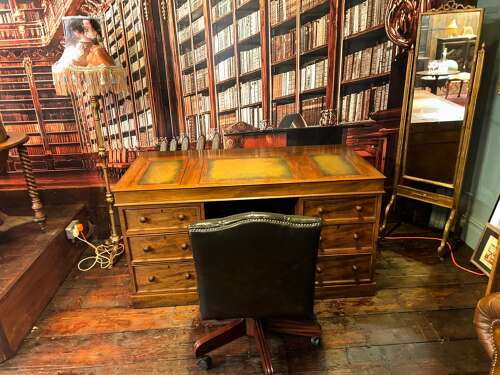 Antique Walnut pedestal desk with a hinged compartment desk with olive green leather top.